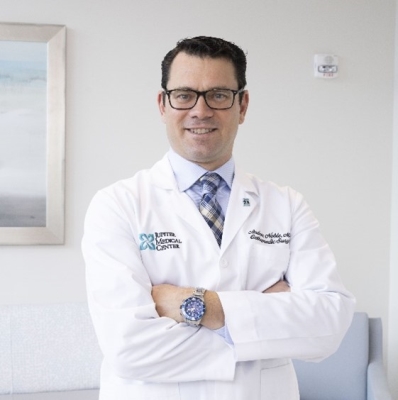A person in a white coat
Description automatically generated